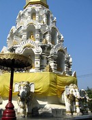 A chedi in the Indian style, with Buddhas in niches and elephants